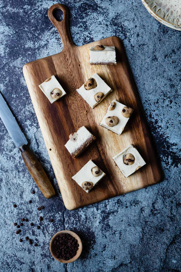 Cookie dough cheesecake bars presented on a board