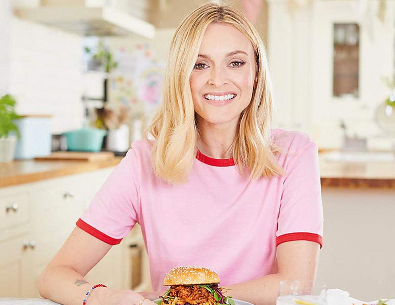 Fearne Cotton in the kitchen eating a vegan burger wearing a pink t-shirt 