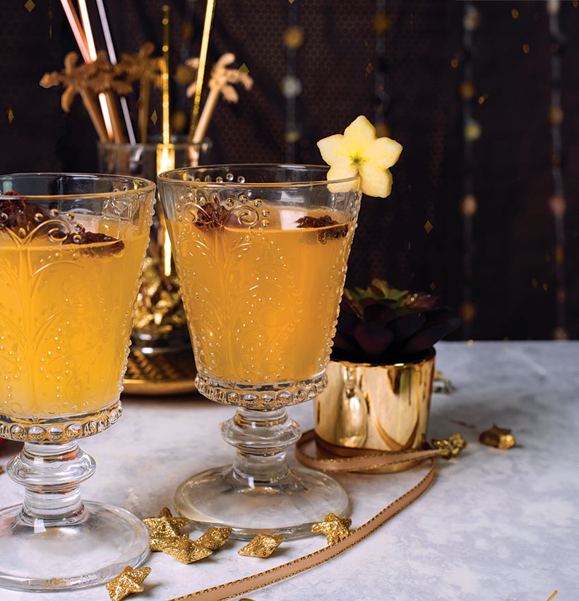 spiced apple cider cocktail in glasses on festive table