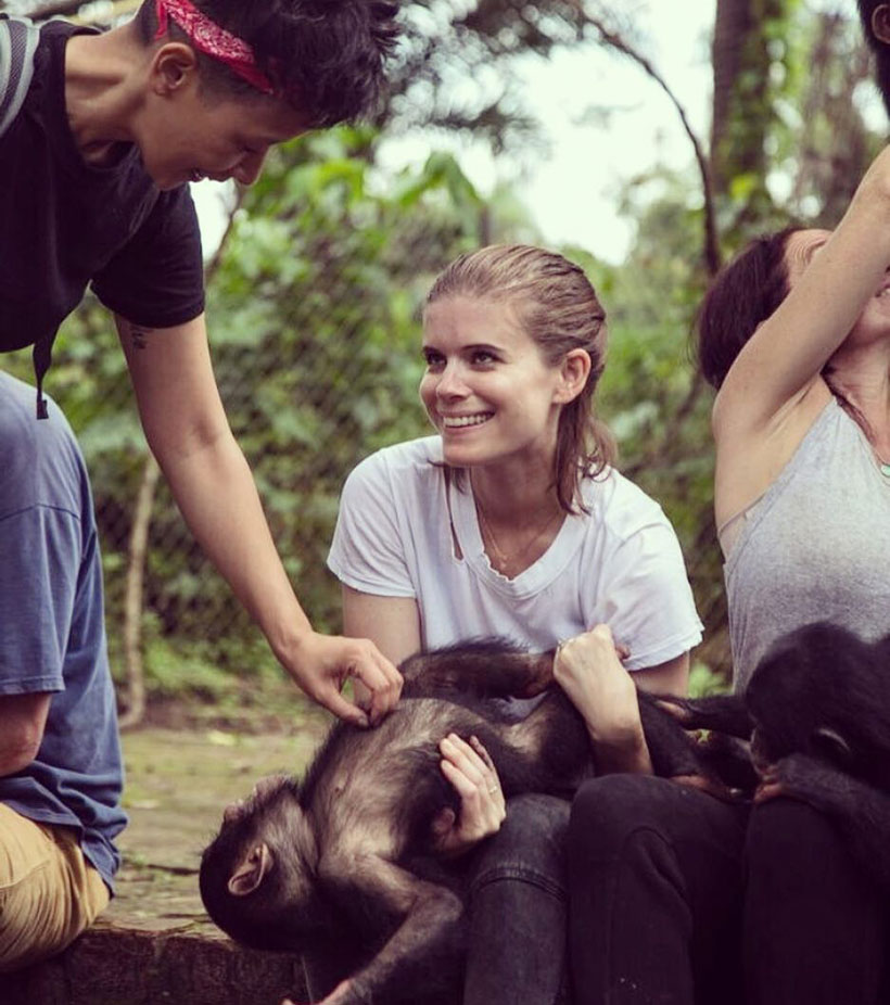 Kate Mara playing with a chimpanze lying in her lap