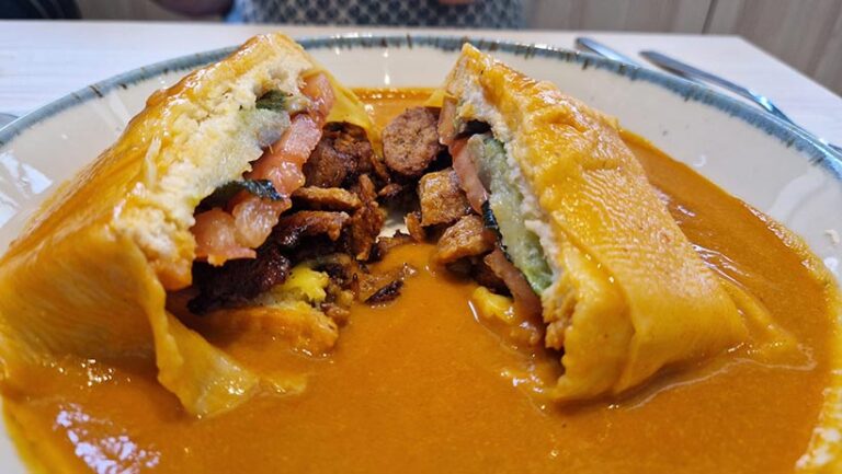 Francesinha is Porto’s signature dish and is a layered sandwich typically filled with slices of meat, topped with melted cheese slices and served in a tomato-and-beer sauce. Kind Kitchen's vegan version is stuffed with layers of smoked tofu, sausage and fresh veggies. 