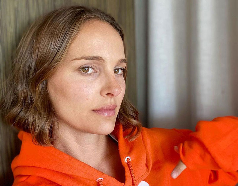 Natalie Portman wearing a bright orange jumper 