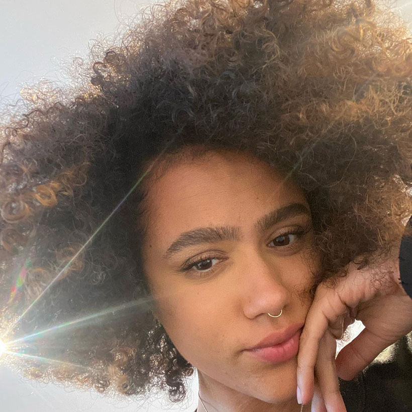 Nathalie Emmanuel taking a selfie with the sun shining behind her head 