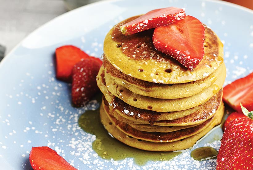 Sweet Potato Pancake Stack with Strawberries and Maple Syrup