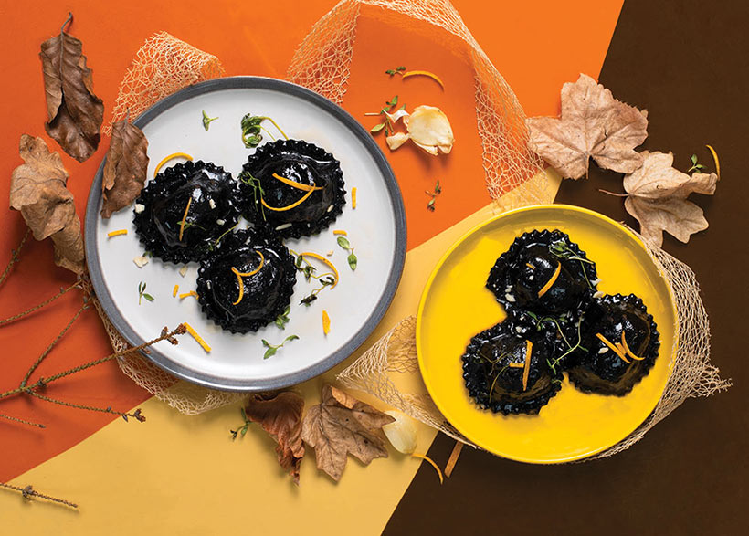 Jet black ravioli on striking orange and brown autumn background