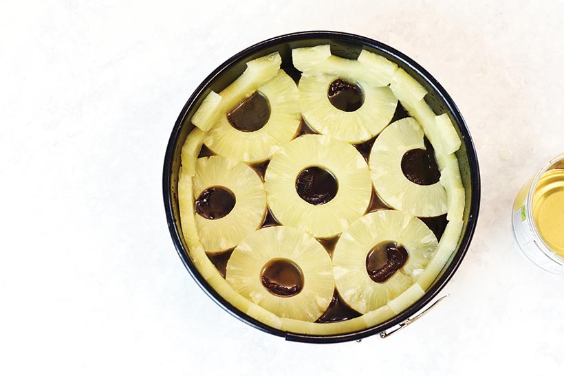 layered pineapple rings at bottom of cake pan