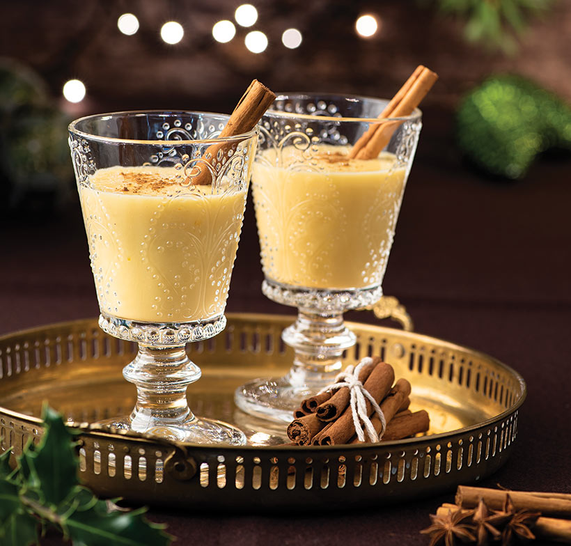 creamy vegan egg nog in glasses with cinnamon stick