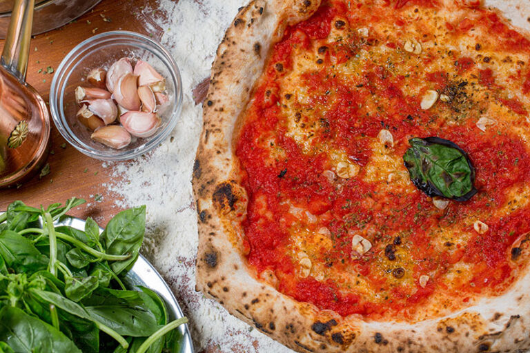 Pizza Marinara is naturally vegan, traditionally topped with only marinara sauce, oregano, garlic, and oil. Photo © seba tataru via Adobe Stock