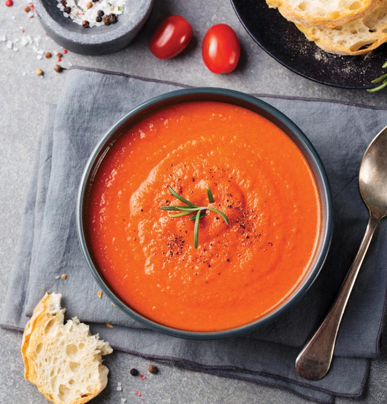 A creamy bowl of tomato soup with bread makes for a simple yet delicious vegan lunch.